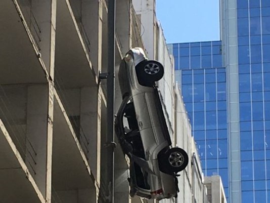 Driver escapes from car dangling off ninth-floor car park (Watch)